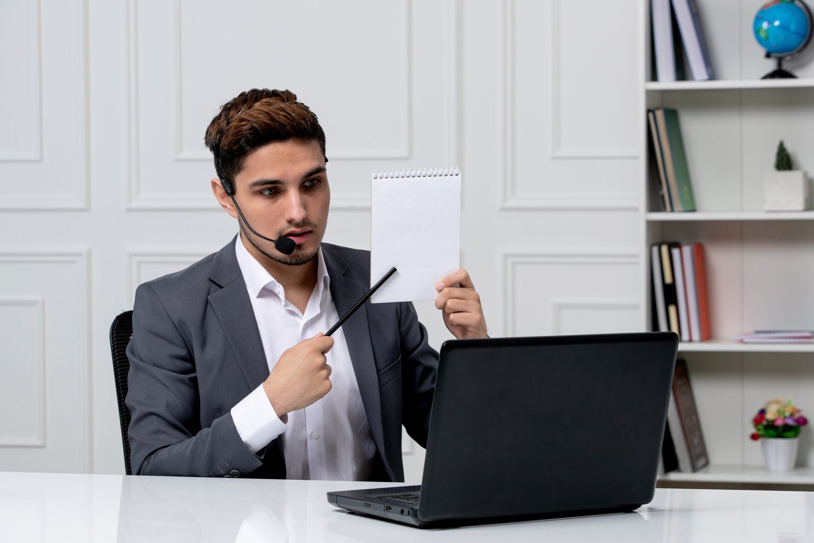 customer-service-young-cute-guy-grey-office-suit-with-computer-showing-notes-paper